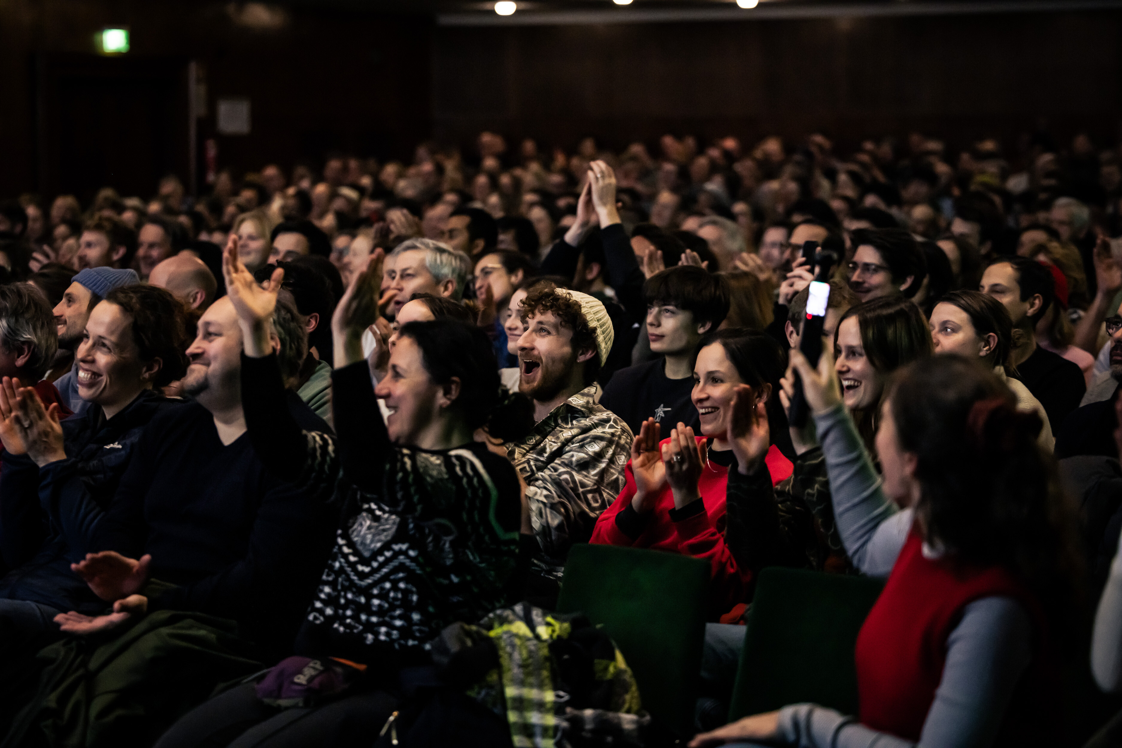 Applauding, laughing audience in the packed hall of a Banff Tour event.