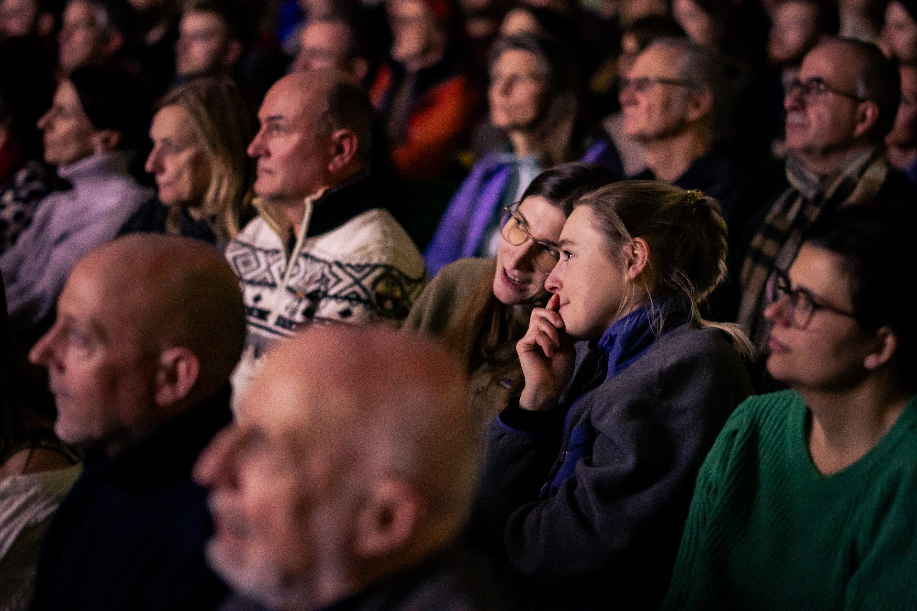 Densely seated audience at a Banff Tour event, watching attentively toward the screen.