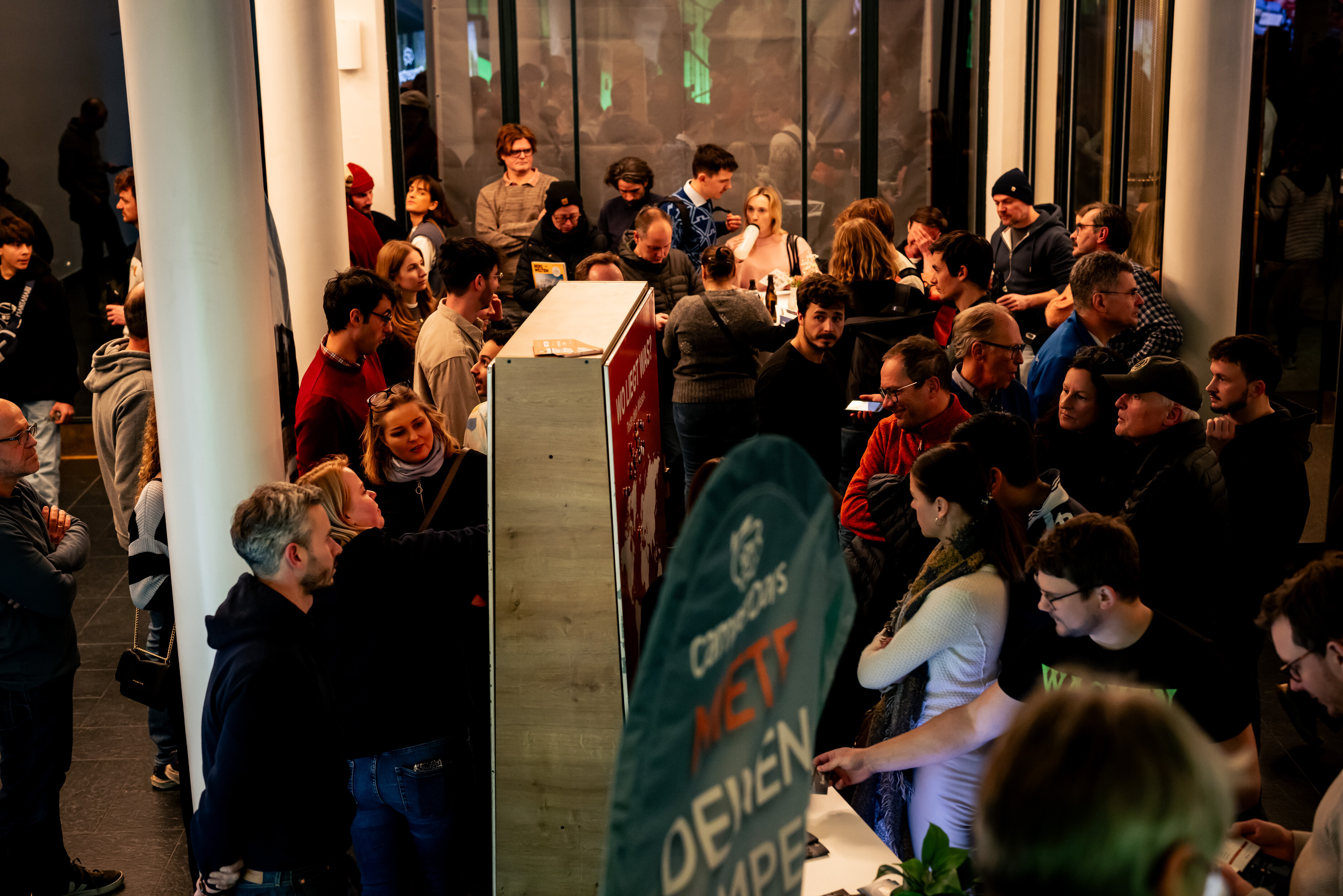 Busy crowd at partner booths in the foyer of the Alte Kongresshalle in Munich during a Banff Tour event.